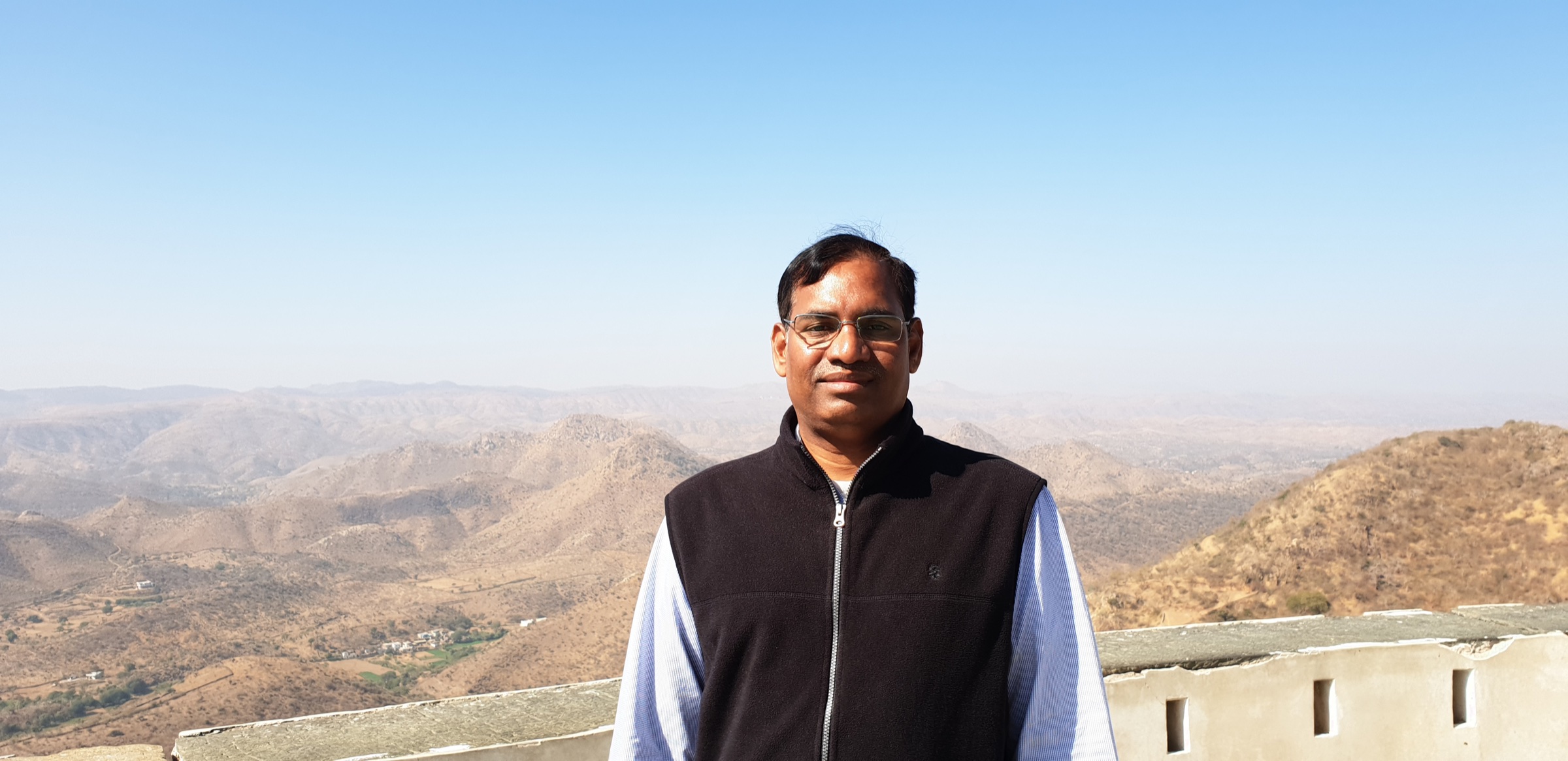 Dr. Arun Kumar Parayatham overlooking a mountain landscape